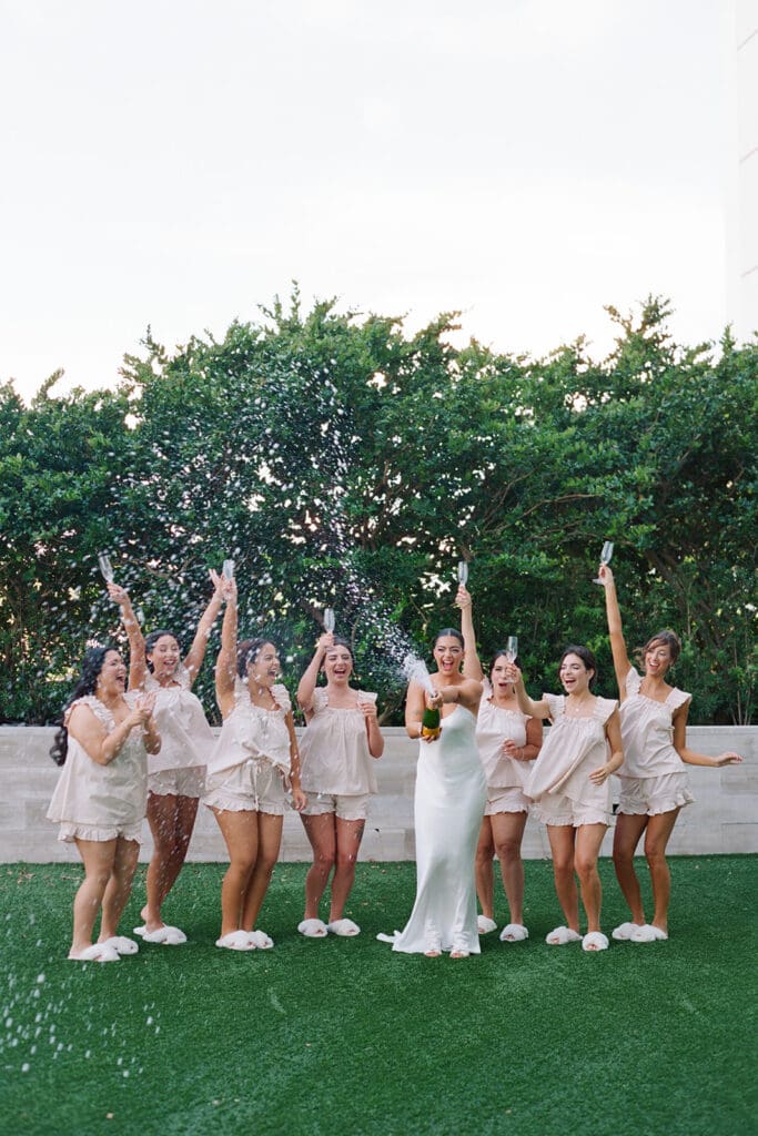 The Miami Beach Edition Wedding bridesmaids popping champagne